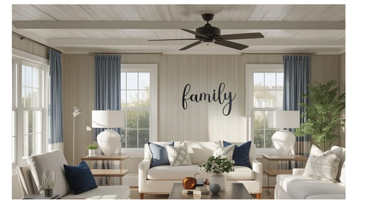 A metal wall art sign, family word hung n a living room wall. Furniture in the foreground. 