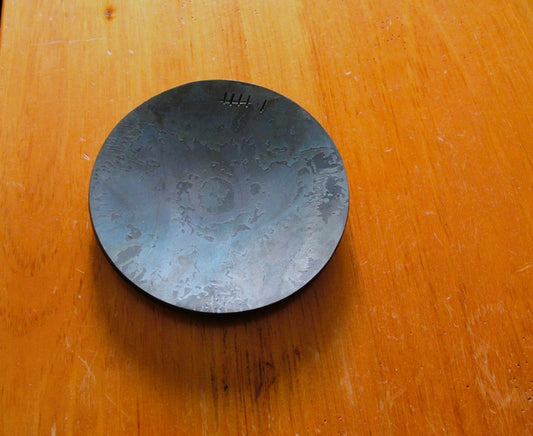 A metal dish, marked with 6 tally marks indicating 6th anniversary.
